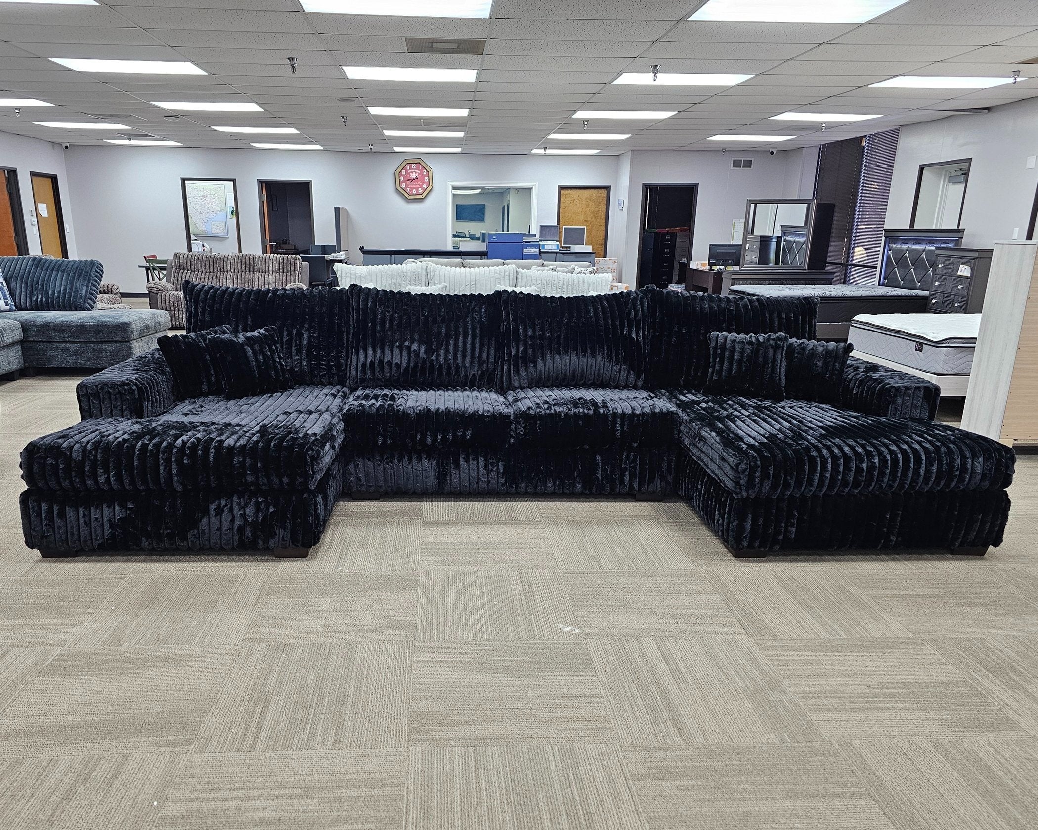 modern black velvet double chaise sectional sofa in showroom setting