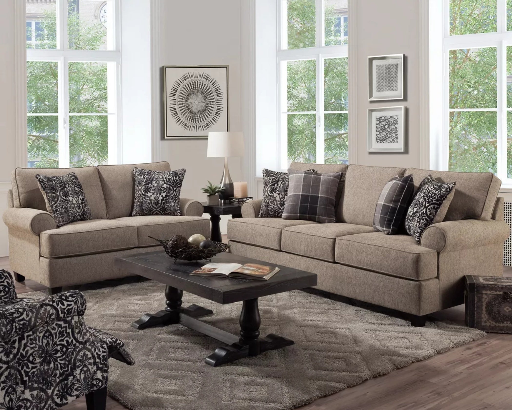 Taupe fabric sofa and loveseat set with patterned accent pillows in a modern living room