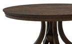 round dark wood dining table with carved edge and pedestal base, traditional style