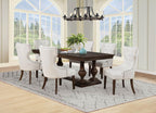 Traditional dark wood dining table set with six upholstered cream chairs in airy dining room