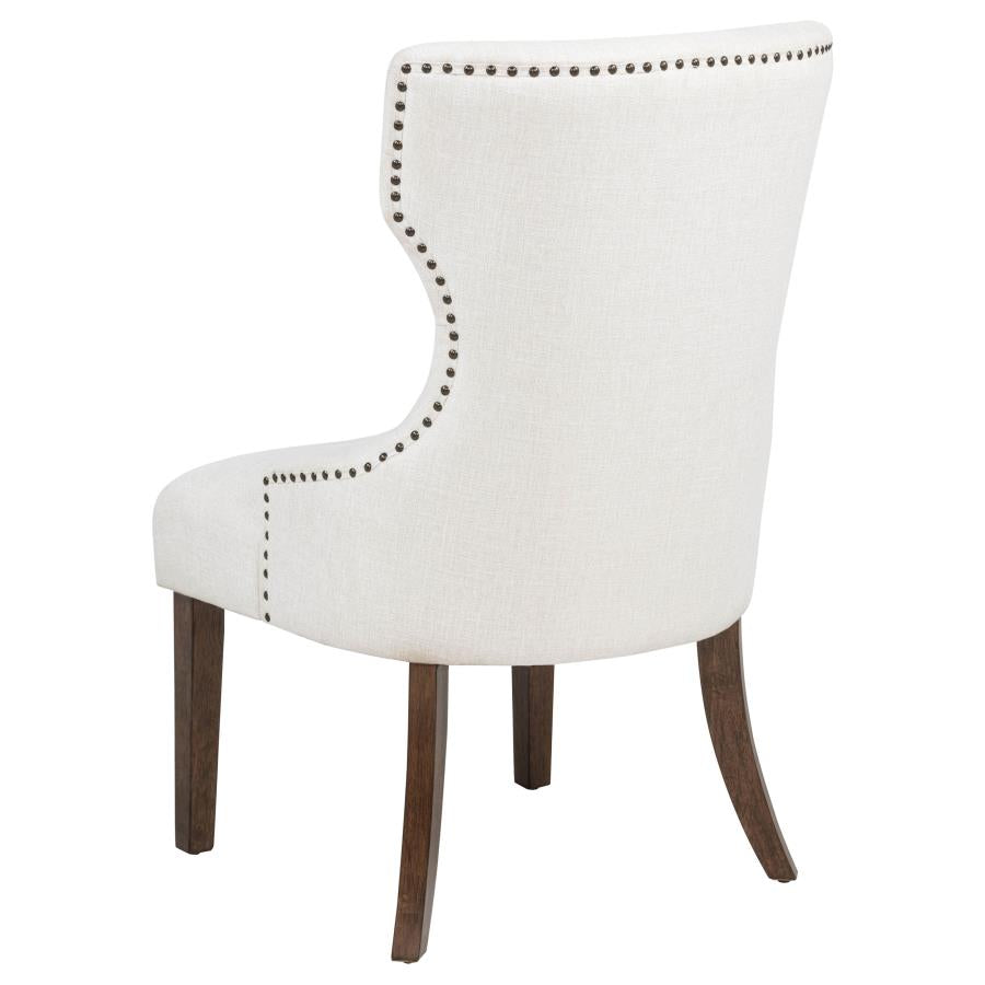 Modern cream upholstered dining chair with nailhead trim and dark wood legs