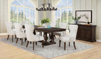 Elegant dark wood dining table with eight tufted cream chairs in a bright modern dining room
