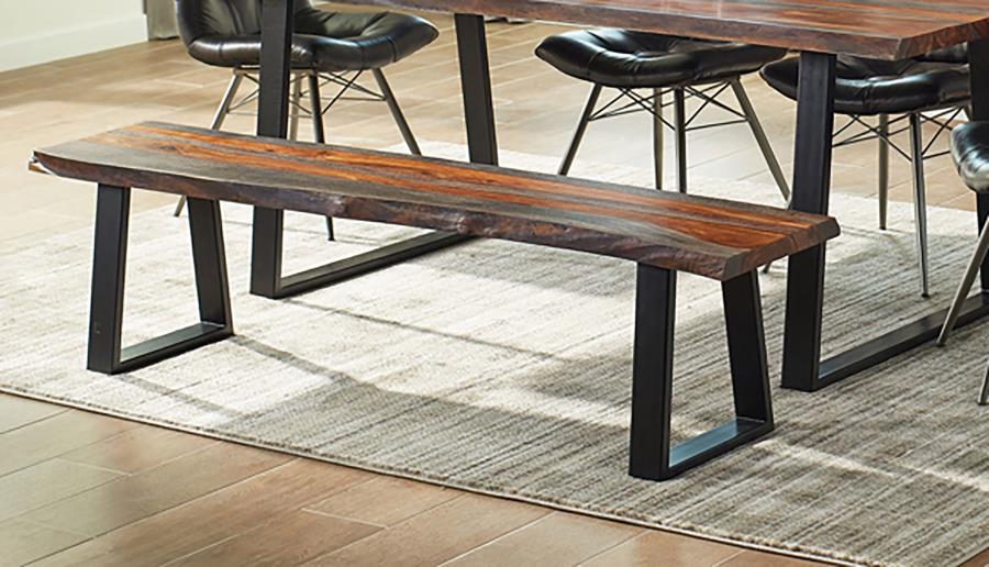 Live edge wood dining bench with natural grain finish and black metal frame legs on geometric area rug.