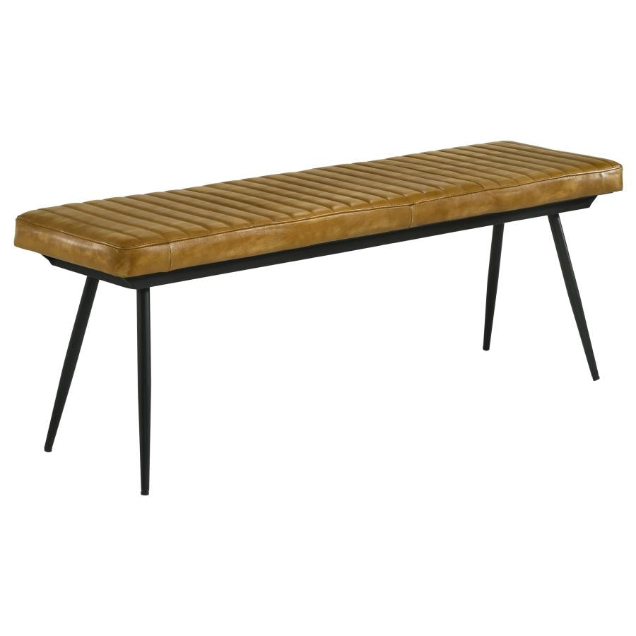 Antique camel leather dining bench with channel stitching and black tapered metal legs on white background.