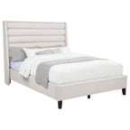 Beige upholstered platform bed with horizontal tufted wingback headboard and black wood legs.