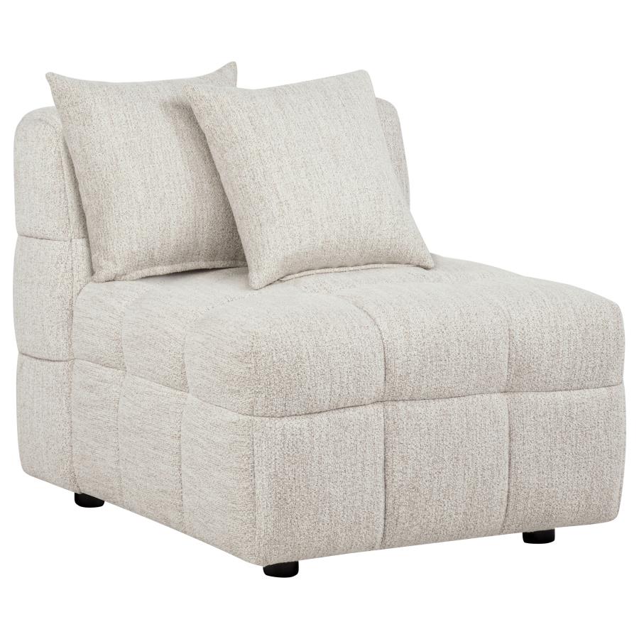 Cream upholstered armless chair with channeled quilted details, two throw pillows, and black legs.