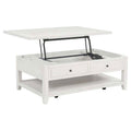 White distressed wood coffee table with lift-top mechanism open, two drawers, lower shelf, and casters.