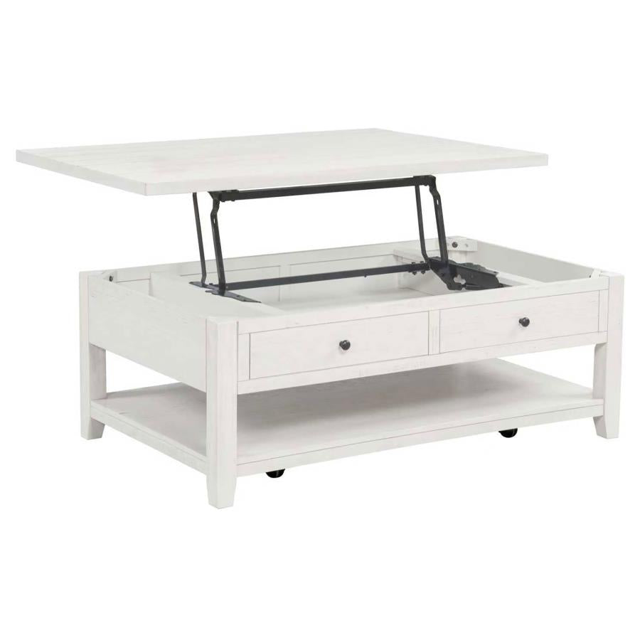 White distressed wood coffee table with lift-top mechanism open, two drawers, lower shelf, and casters.