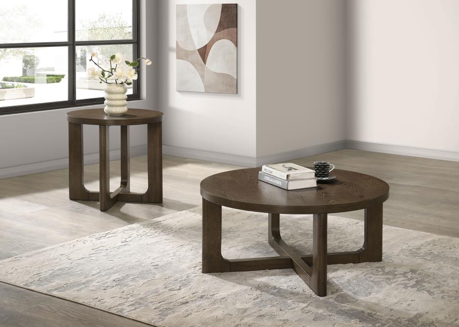 Two round brown wood coffee tables with sculptural open bases displayed on a light area rug in a minimalist living room.