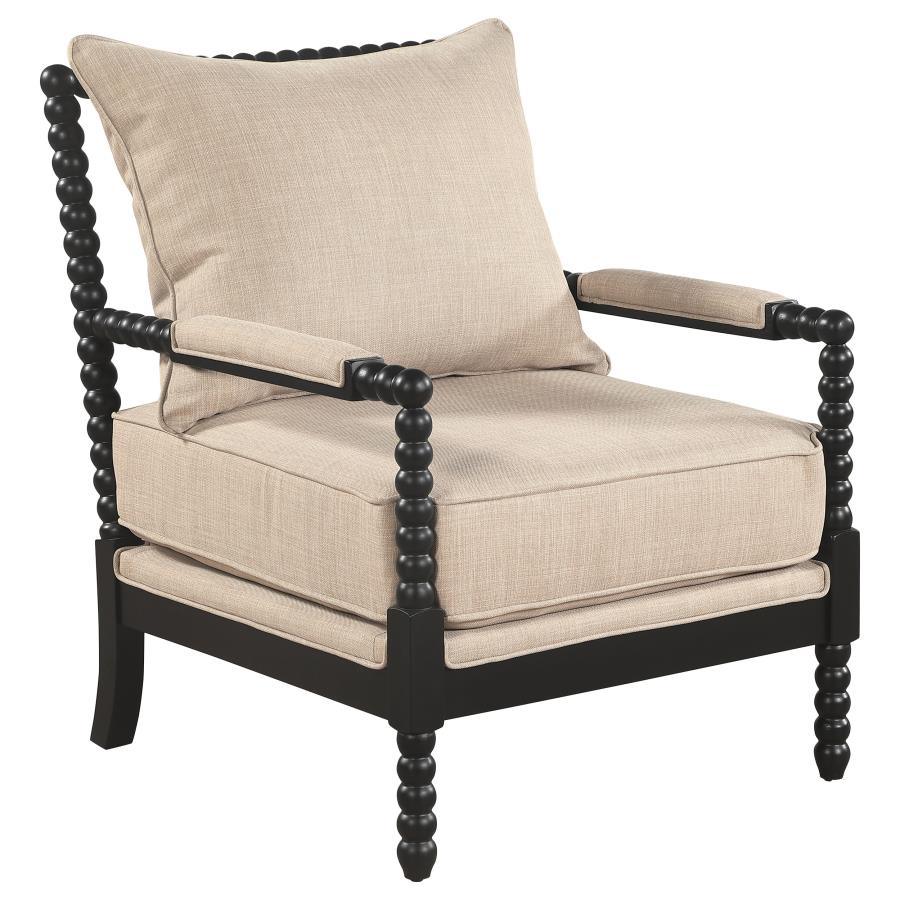 Beige upholstered accent chair with black bobbin-turned wooden frame and armrests on white background.