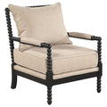 Beige upholstered accent chair with black bobbin-turned wooden frame and armrests on white background.