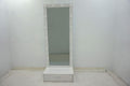 White high-gloss floor mirror with integrated LED lights around frame and matching storage drawer base.